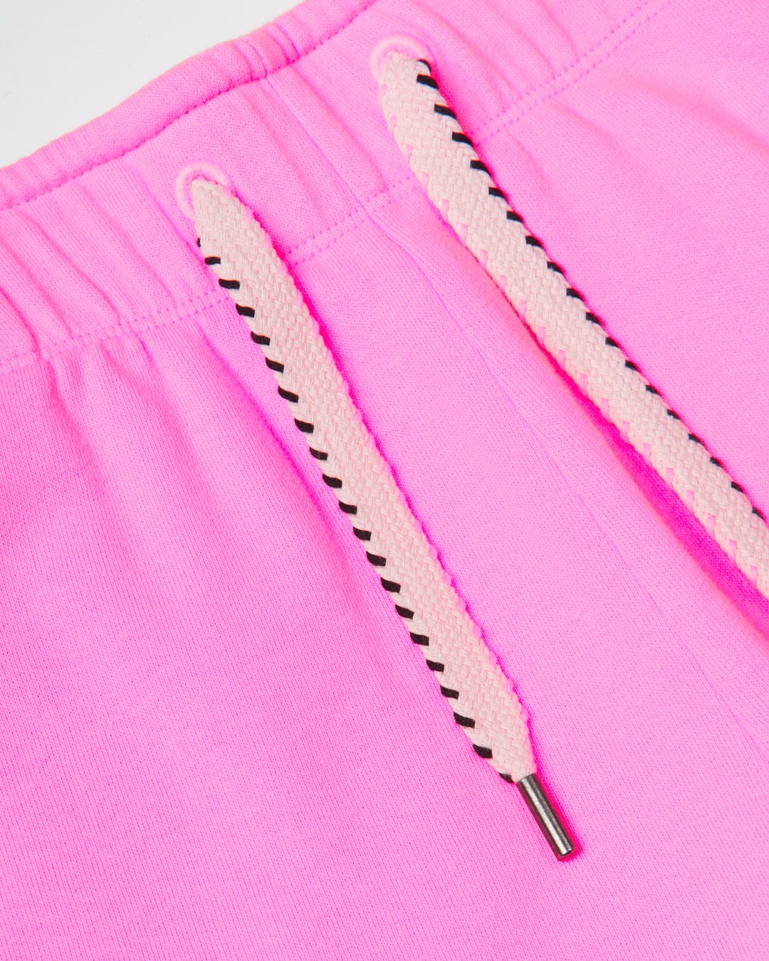 Close-up of a pink Saltrock Instow branded fabric with a white and black drawstring, emphasizing the texture and details of the material and cord ends.
