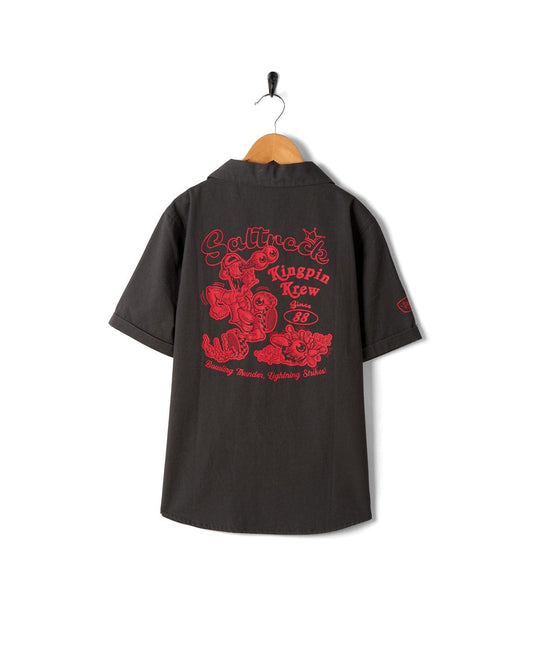 A Saltrock Kingpin Krew - Kids Short Sleeve Shirt - Dark Grey with a red design on it.