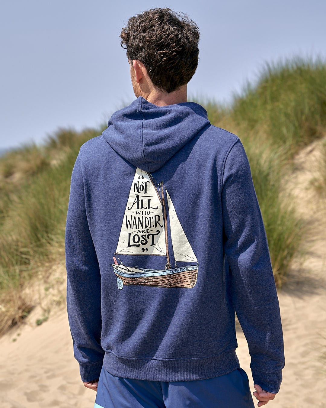 The man with a Lost Ships - Mens Pop Hoodie - Blue Marl on his Saltrock hoodie looks lost as he wanders through the crowd.