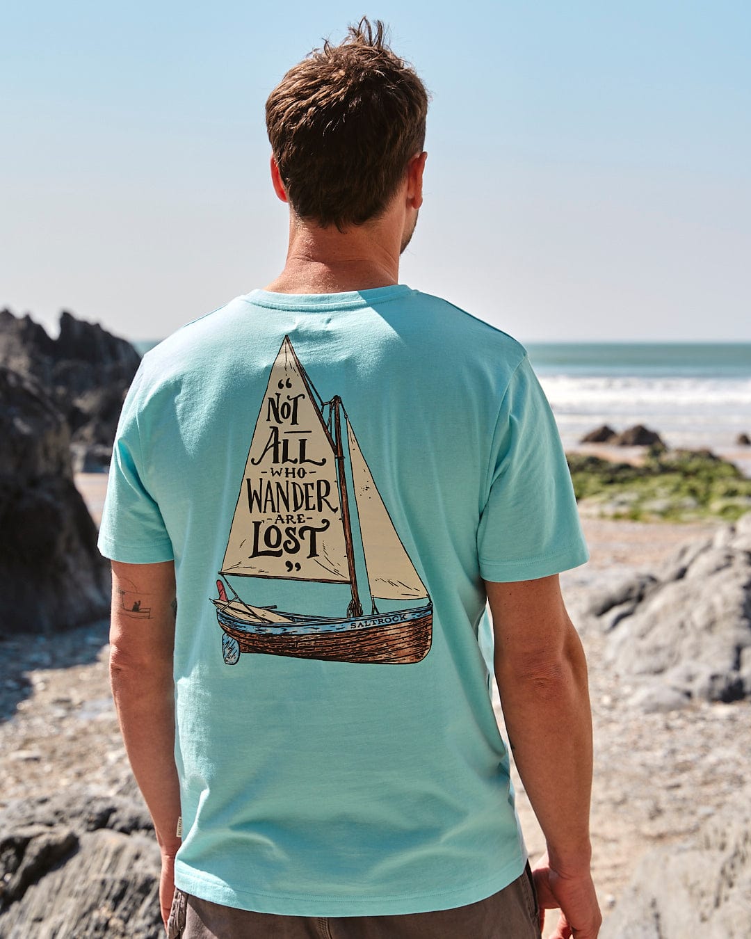 The back of a man wearing a Lost Ships - Mens Short Sleeve T-Shirt in Turquoise, representing the Saltrock brand.