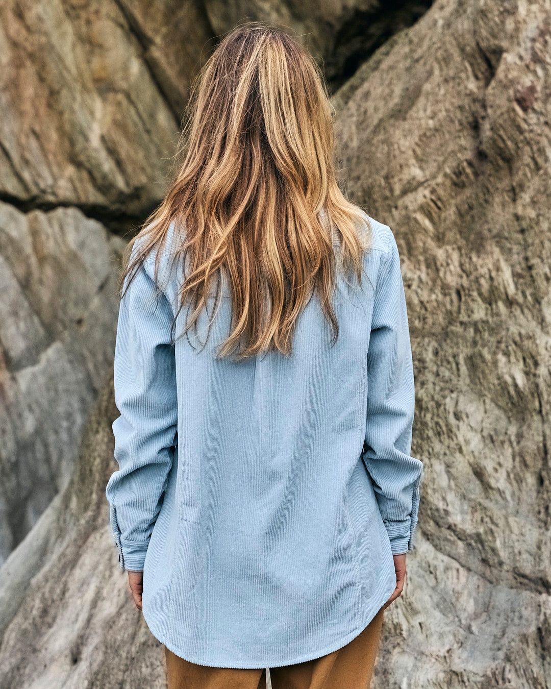 A stylish woman wearing a blue Saltrock Maddox - Womens Cord Shirt - Light Blue.