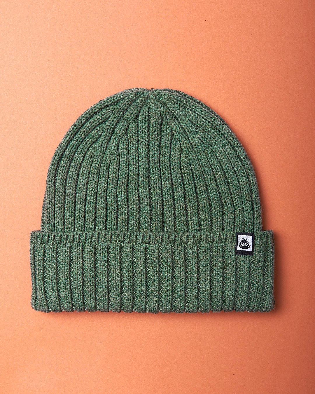 A Saltrock Maine - Fisherman Beanie - Green on an orange background.
