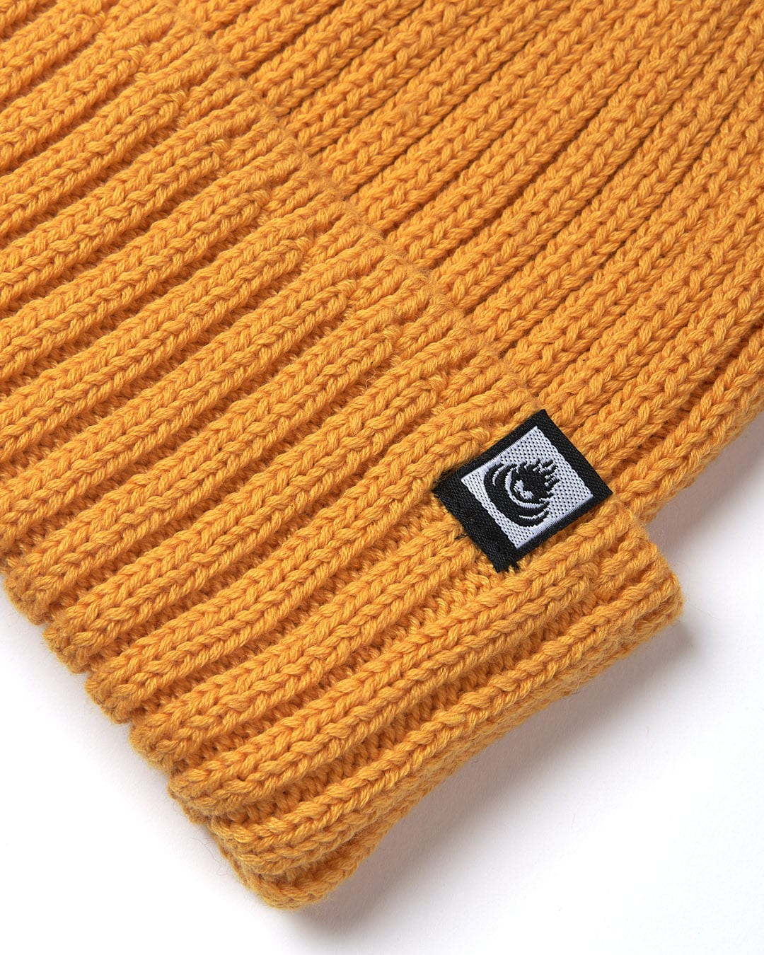 A stylish Saltrock Maine Fisherman Beanie providing warmth on a white surface.