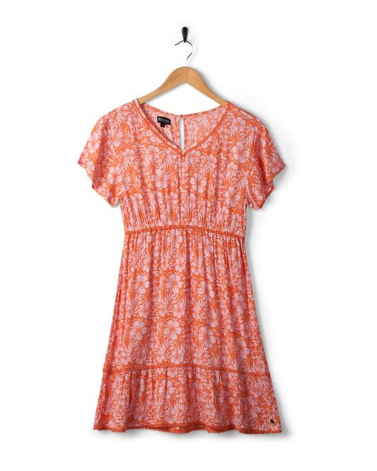 Marla Hibiscus dress by Saltrock hanging on a wooden hanger against a white background.