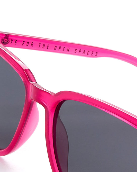 A pair of Saltrock Marshall - Recycled Polarised Sunglasses - Pink with UV protection on a white surface.