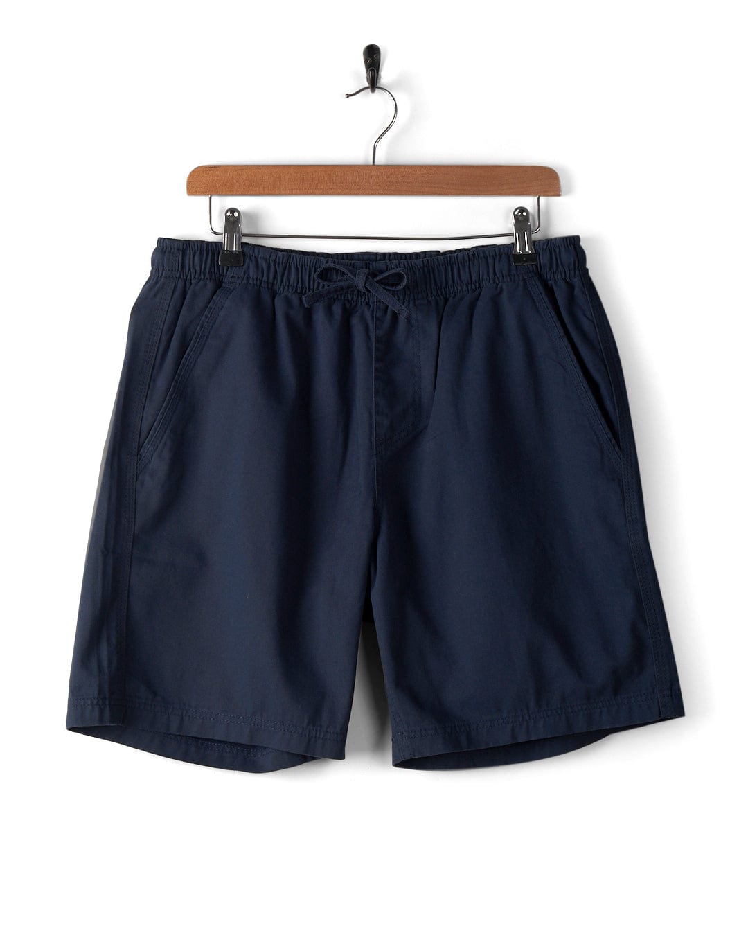 Saltrock Meddon Mens Chino Shorts in blue, featuring a relaxed fit and elasticated waist, hang on a wooden hanger against a white background.