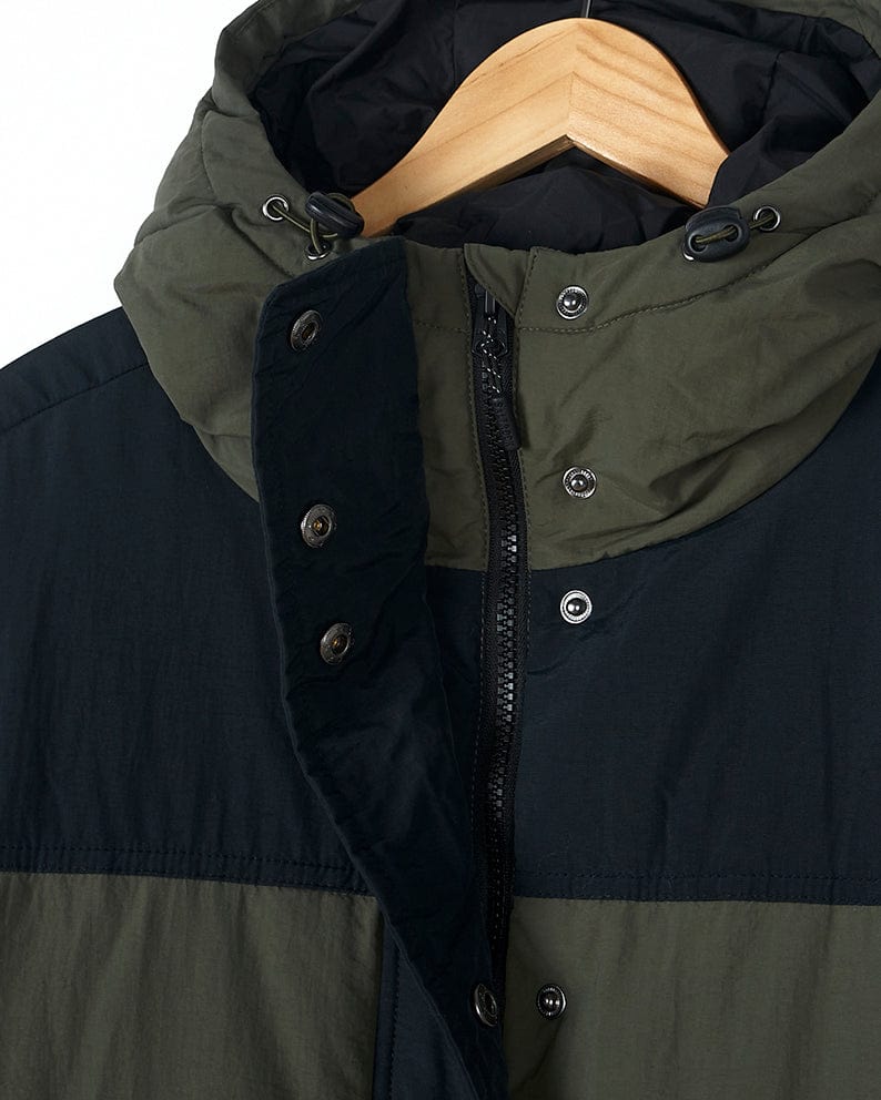 A Saltrock Merle - Womens Puffer Jacket - Dark Green hanging on a hanger.