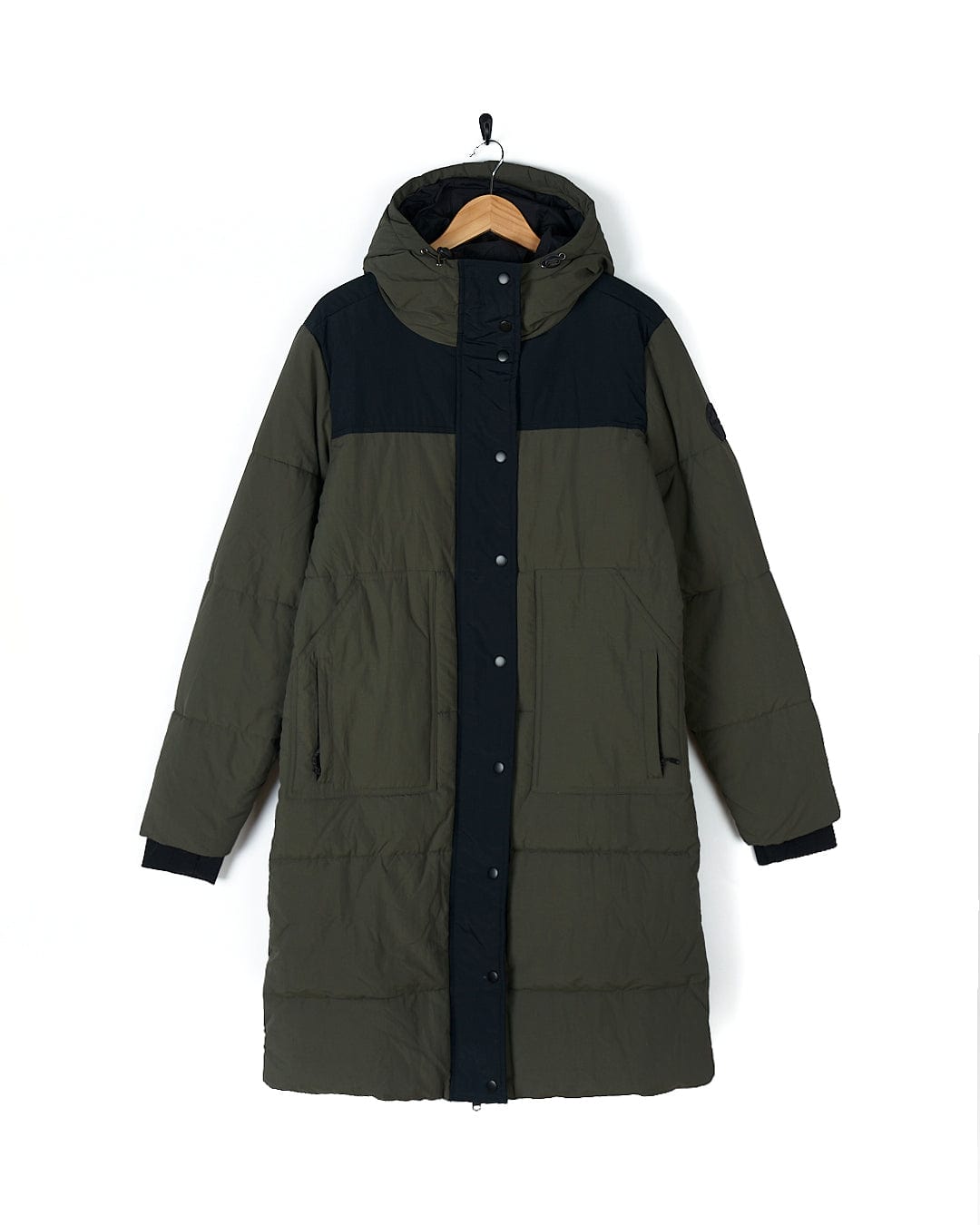 A Saltrock Merle - Womens Puffer Jacket - Dark Green hanging on a hanger.