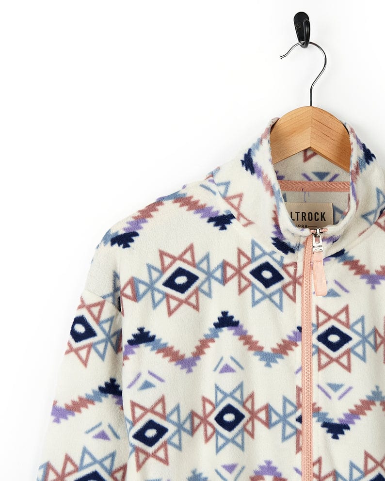 A women's Micro Ida - Womens Zip Fleece - Cream, adorned with Saltrock branding, hanging on a hanger.