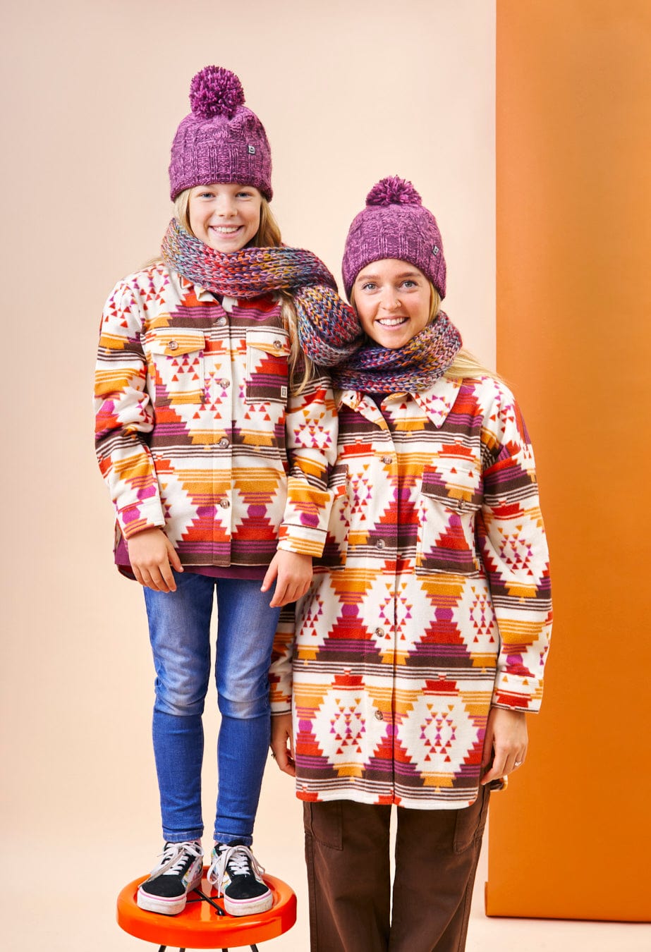 A mother and daughter pose for a photo in a Saltrock Dallyn Womens Aztec Fleece Shacket - Orange, showcasing its colorful Aztec print.