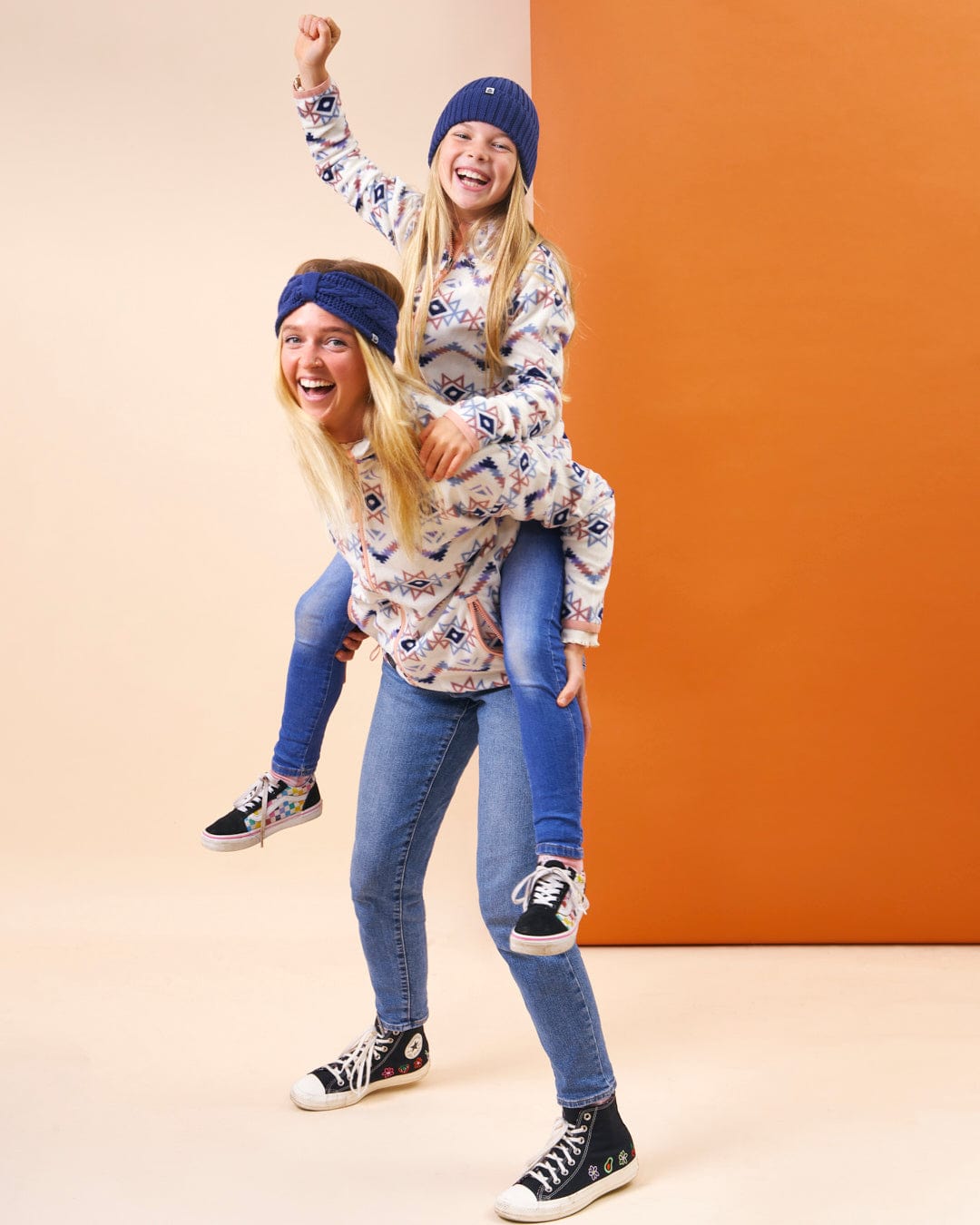 A woman is riding a little girl in a cozy Saltrock Micro Ida - Kids Zip Fleece - Cream sweater.