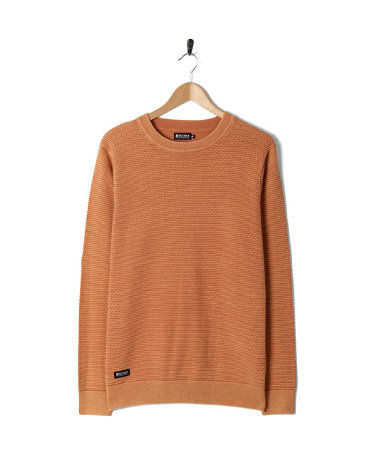 A Moss - Mens Washed Knitted Crew - Orange sweatshirt hanging on a hanger.