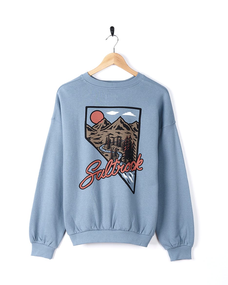 The Mountain Creek Almira - Womens Balloon Sleeve Sweat - Blue by Saltrock is a cozy blue sweatshirt featuring a stunning image of a mountain and a sunset.