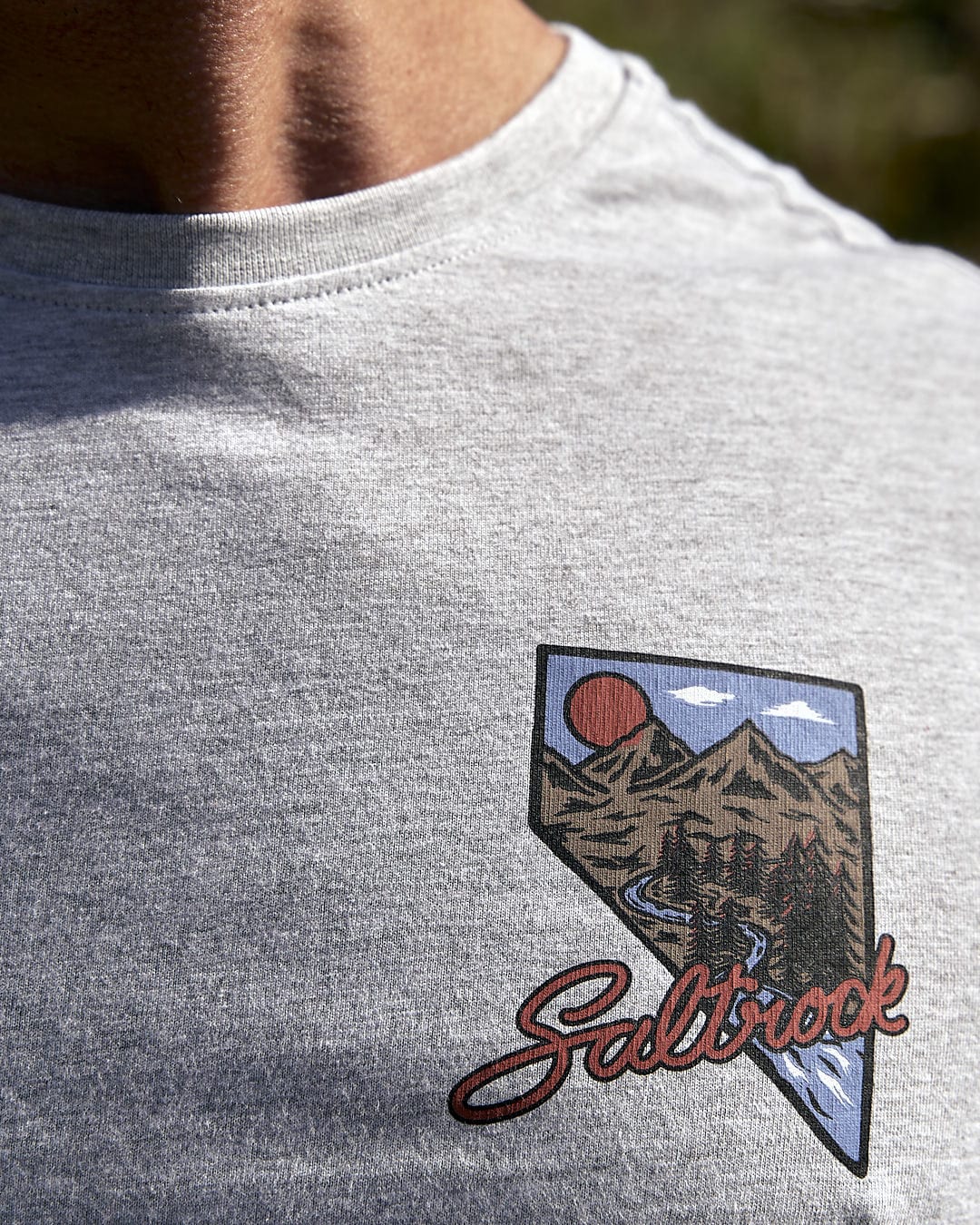 A man is wearing a Mountain Creek - Mens Long Sleeve T-Shirt - Grey that says Saltrock.