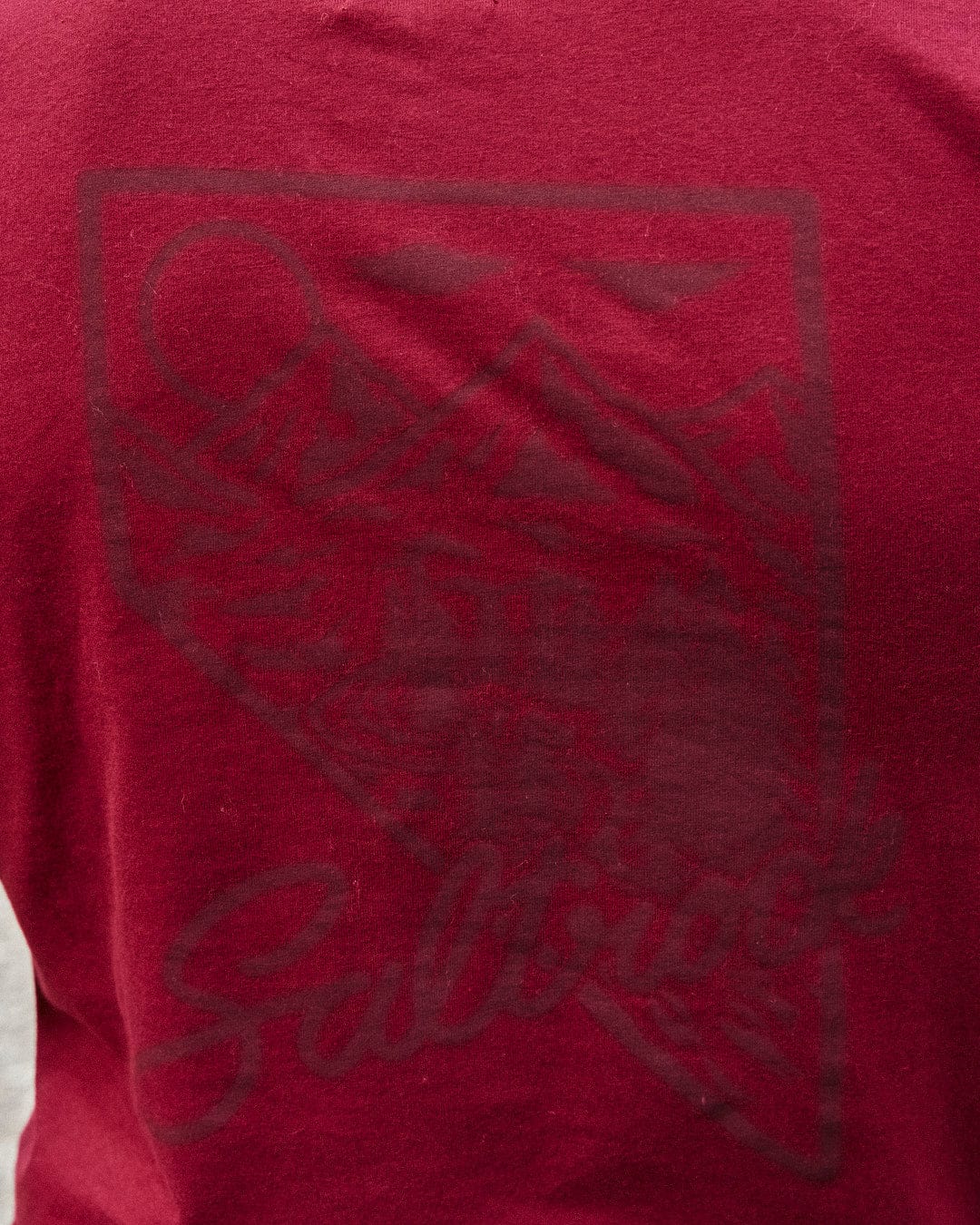 The man wearing a Mountain Creek - Mens Short Sleeve T-Shirt - Red has Saltrock branding on it.