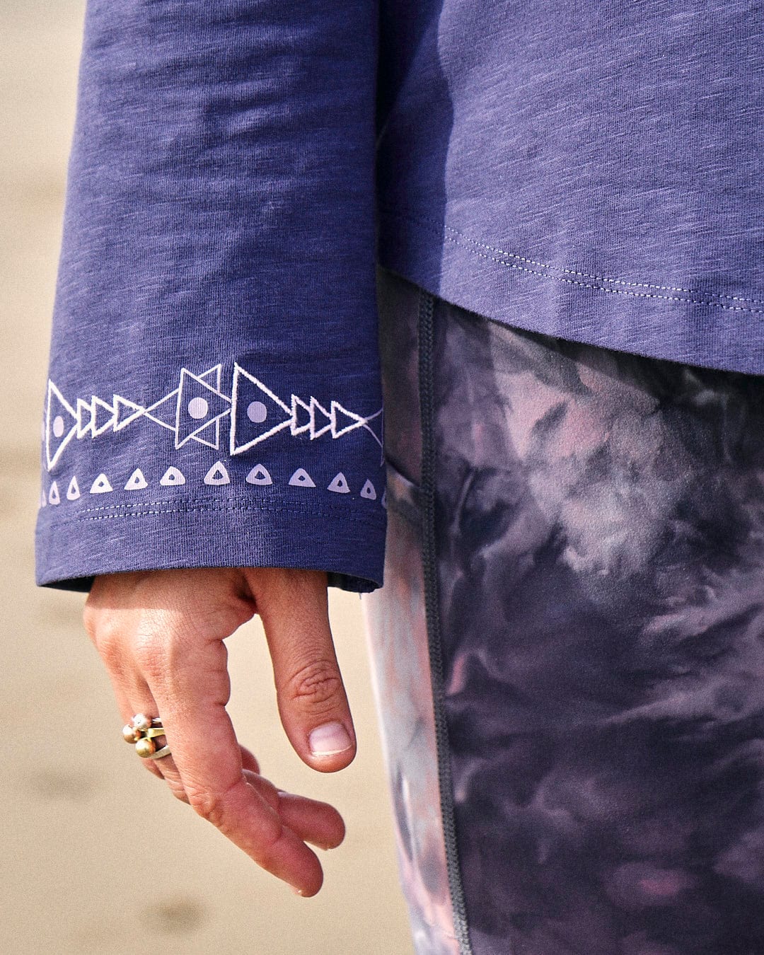 A woman wearing a Saltrock Mountain Rise - Womens Flared Sleeve T-Shirt in Purple with a pattern on it.