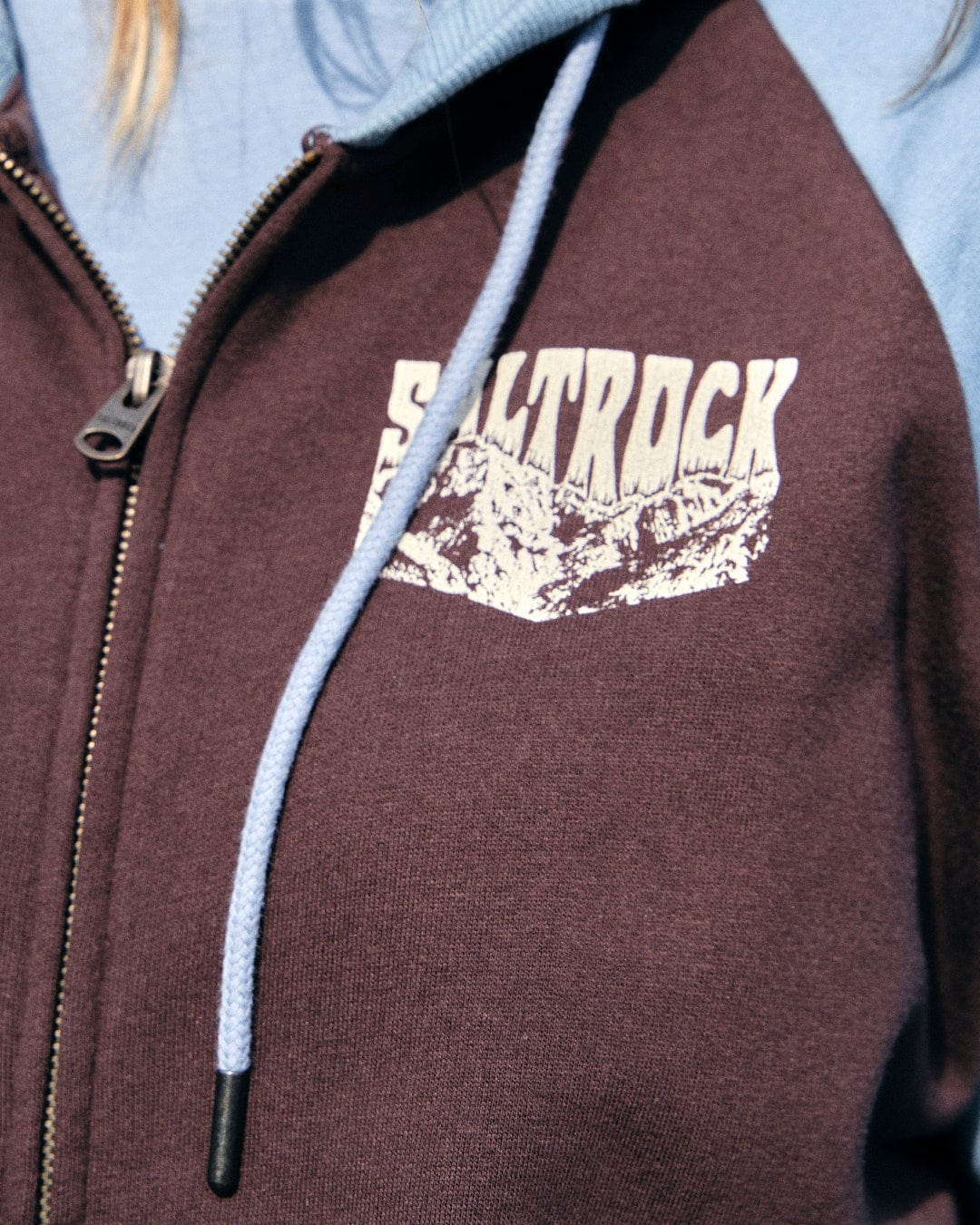 An adventurous woman wearing a Saltrock Mountain Roaming - Womens Raglan Zip Hoodie - Brown with the word rock on it.