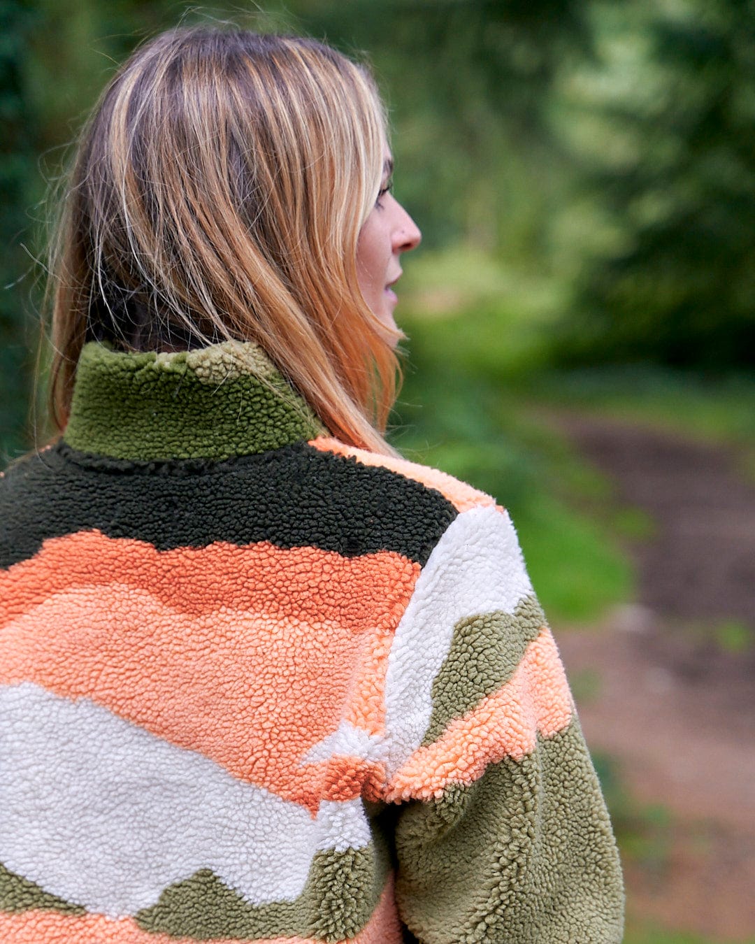 The back of a woman wearing a Saltrock Mountain Scape - Womens 1/4 Fleece - Orange jacket.