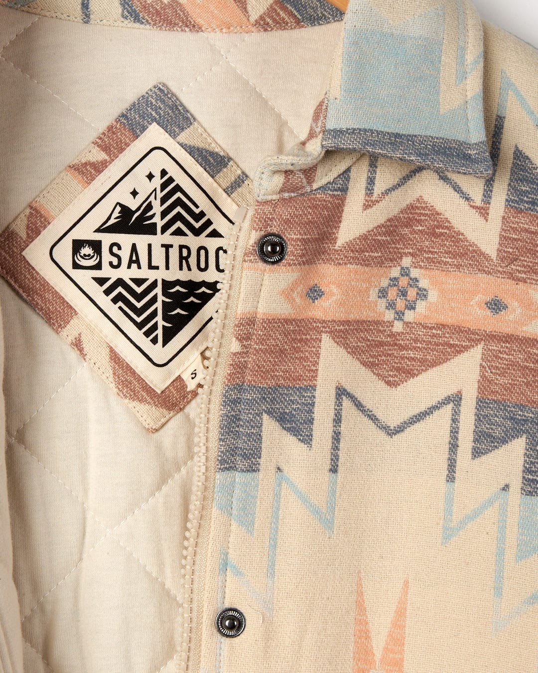 Close-up of a Mylene - Aztec Shacket - Cream with a geometric pattern and a Saltrock brand label on the collar.