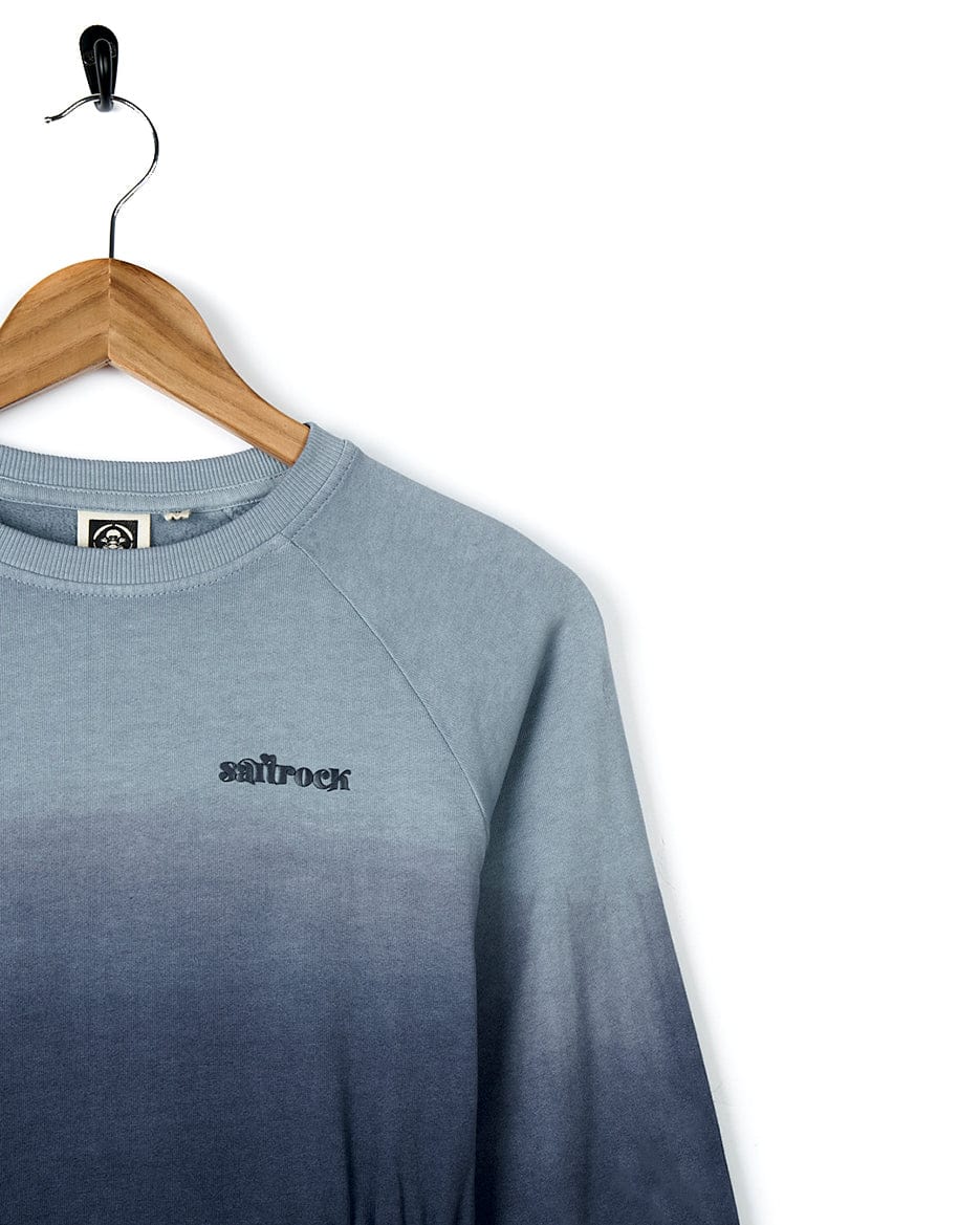 The Saltrock Nola - Kids Dip Dye Sweatshirt - Blue is a perfect addition to your casual weekend attire. It features a beautiful blue and black ombre logo and is displayed elegantly on a h