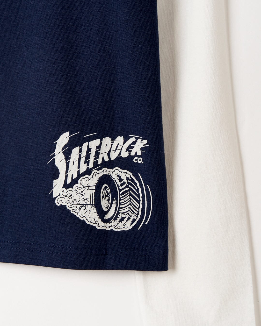 Two No Road No Problem - Kids Long Sleeve T-Shirts, one navy blue and one white, with the hem of the blue shirt displaying a Saltrock Illustration graphic logo.