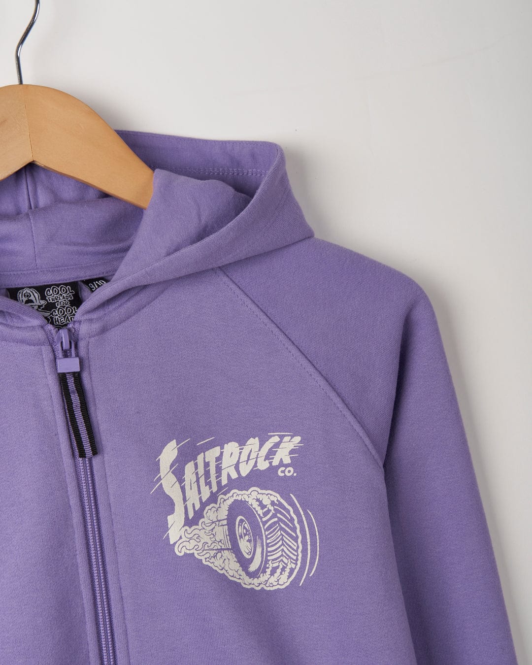 Purple No Road No Problem - Recycled Kids Zip Hoodie with Saltrock branded graphics, hanging on a wooden hanger against a plain background.