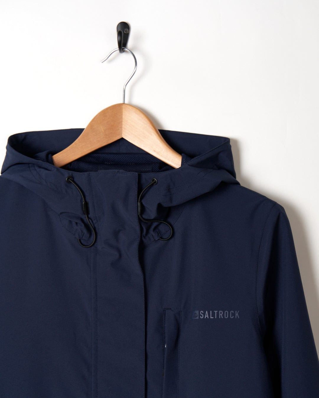 A North West - Womens Waterproof Jacket - Blue with a hood on a wooden hanger against a white background, with the brand name 'saltrock' visible on the front.