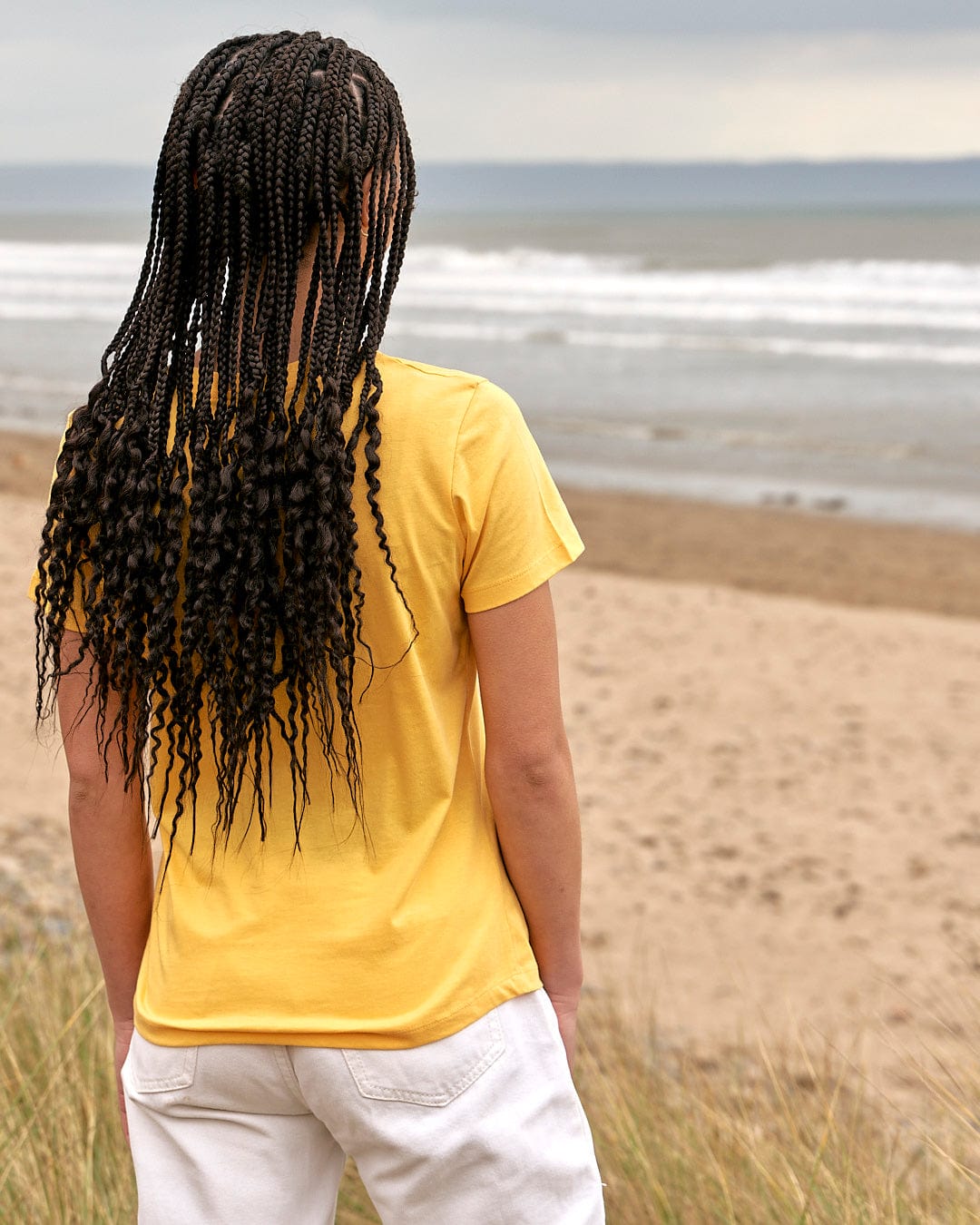 A woman wearing the Saltrock On The Road Wales - Womens Short Sleeve T-Shirt - Yellow.