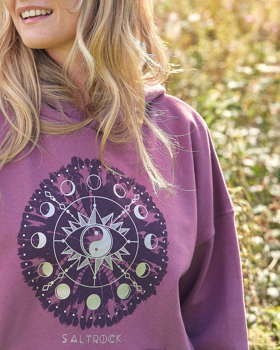A woman wearing a purple Ophelia - Womens Pop Hoodie - Purple Saltrock hoodie in a field.