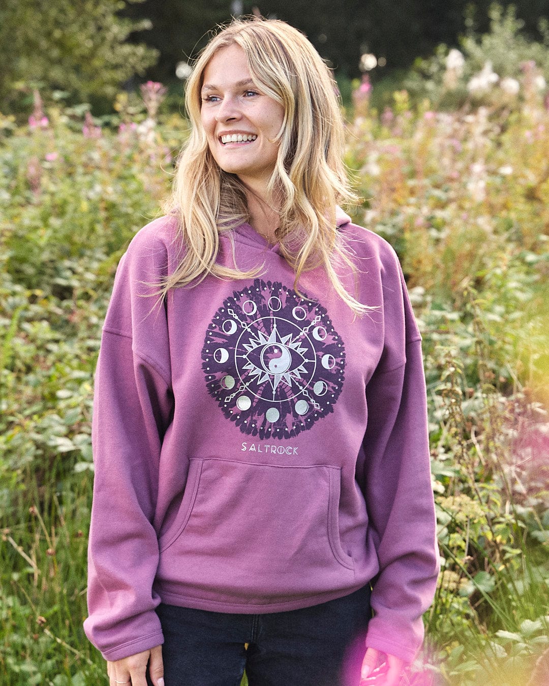 A woman wearing a Saltrock Ophelia - Womens Pop Hoodie - Purple in a field.