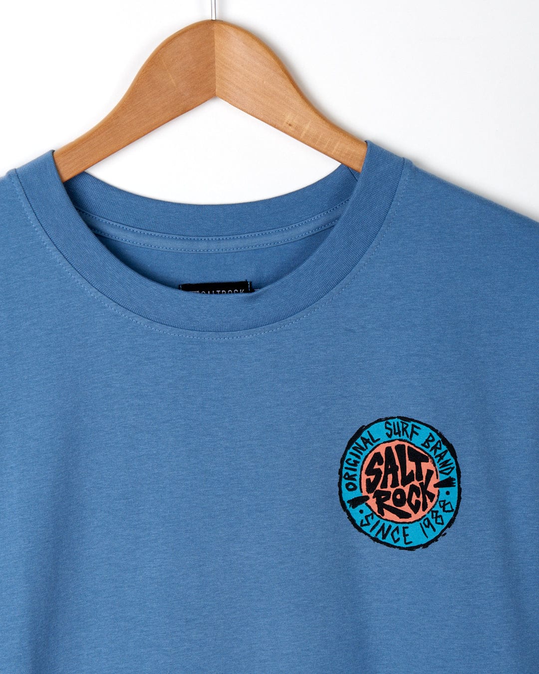 SR Original - Mens Short Sleeve T-Shirt in Blue on a wooden hanger featuring a small circular Saltrock logo on the chest.