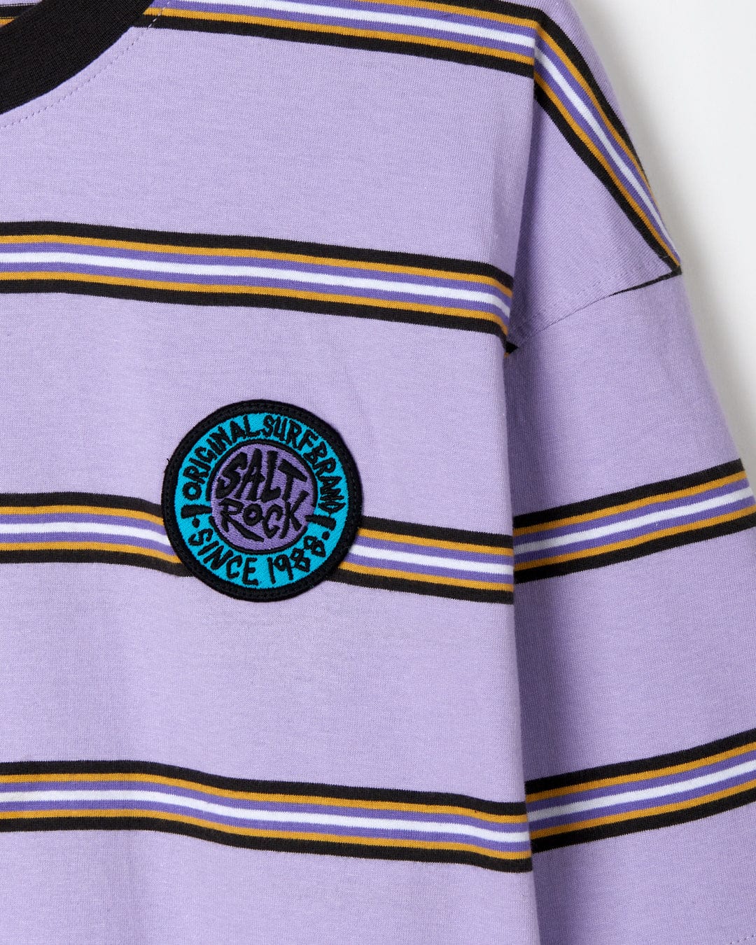 Striped purple and black Saltrock oversized t-shirt with a circular brand patch on the sleeve.