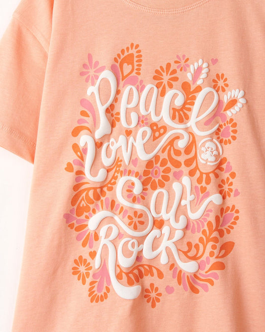 Pink cotton t-shirt with a graphic design featuring the words "peace love cat rock" surrounded by floral and heart patterns, like the Peace Love Kids Short Sleeve T-Shirt in Peach by Saltrock.