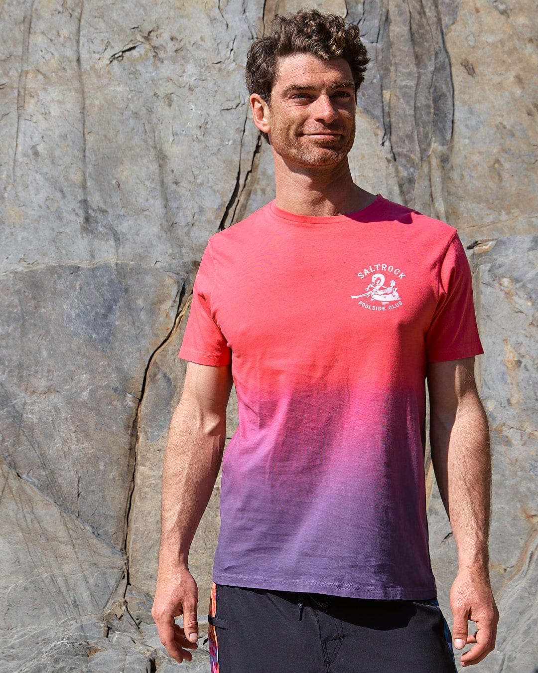 A man wearing a Saltrock Poolside - Mens Dip Die Short Sleeve T-Shirt - Pink and purple t-shirt.