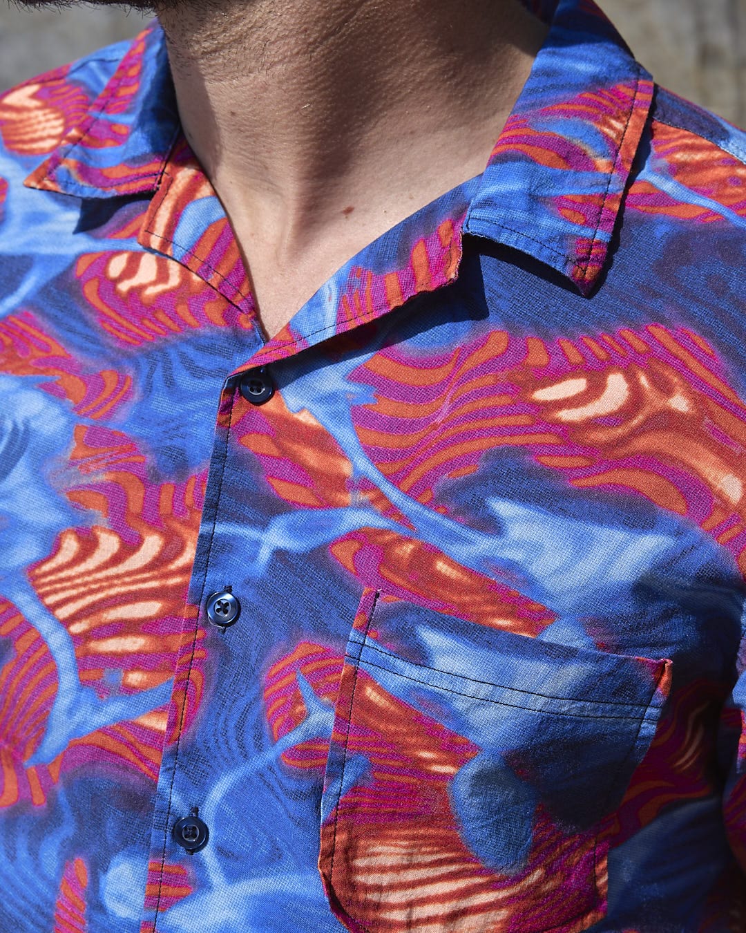 A man wearing the Saltrock Poolside - Mens Short Sleeve Shirt, a bright and fun style, lightweight fabric, blue and red Hawaiian shirt.