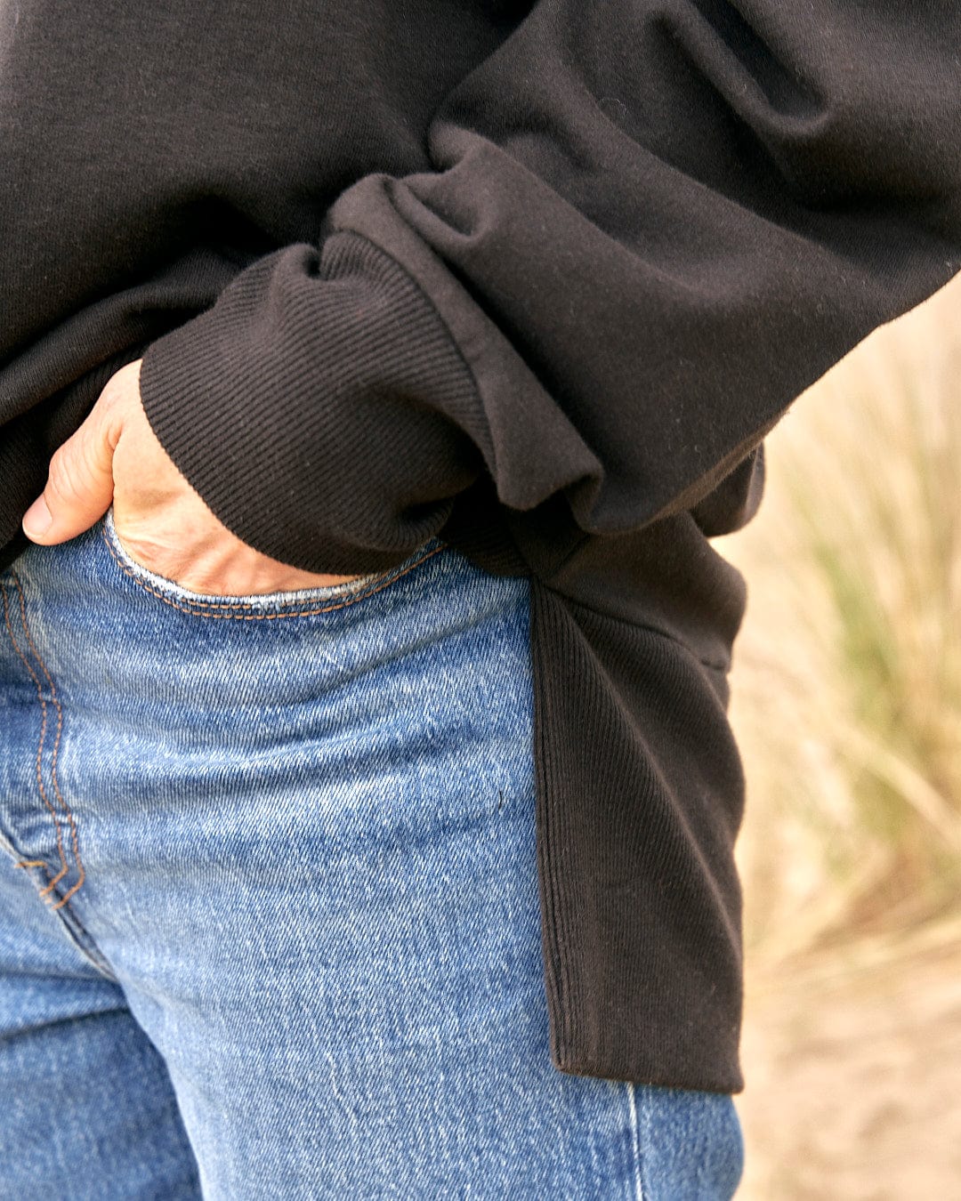 A woman wearing jeans and a Saltrock Purfect Wave Gradient - Womens Boyfriend Fit Sweat - Black sweatshirt.