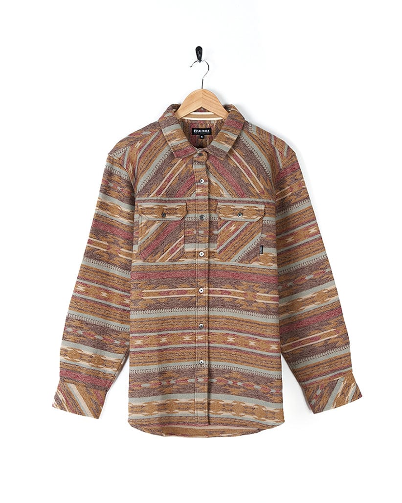 The Saltrock Quinn - Womens Heavy Overshirt - Brown with buttoned cuffs is hanging on a hanger.