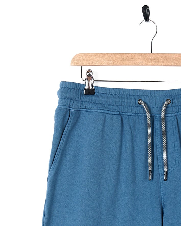 A pair of Saltrock - Ralfen Mens Slimfit Sweatpants - Blue hanging on a hanger.
