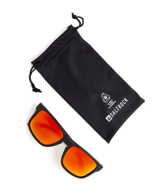 A pair of Saltrock Ranger - Recycled Polarised Sunglasses in Black with orange lenses, perfect for protecting your eyes from harmful UV rays. Includes a pouch for easy storage.