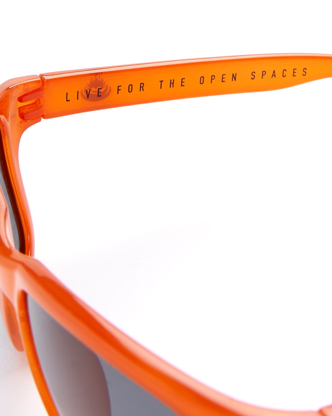 A pair of Ranger - Recycled Polarised Sunglasses - Orange with UV400 protection and a message that reads "Live for the open spaces" on the frame. (Saltrock)