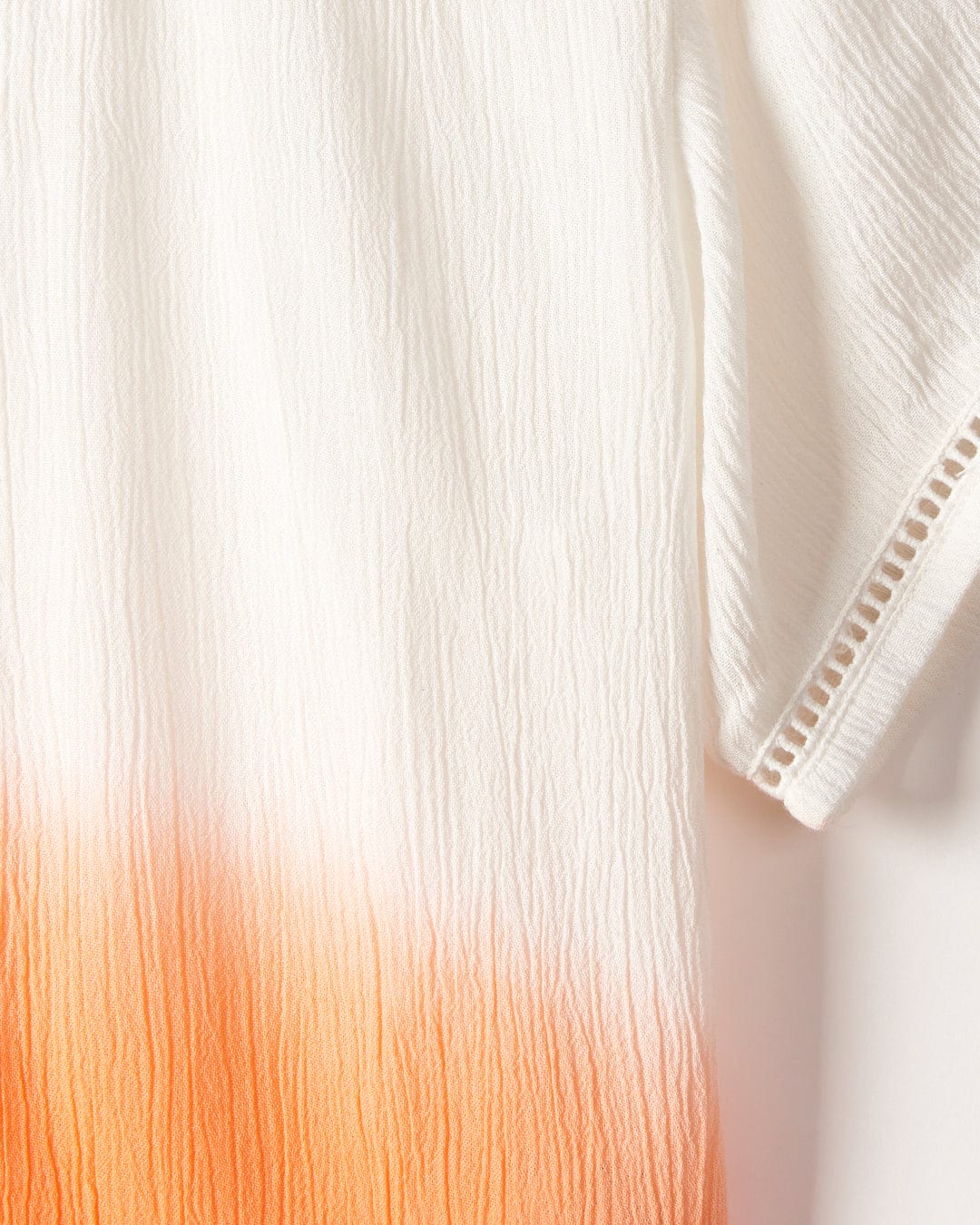White fabric with a gradient ombre effect at the bottom, hanging vertically with a subtle texture visible, like the Saltrock Raya - Kids Shirt - Orange.
