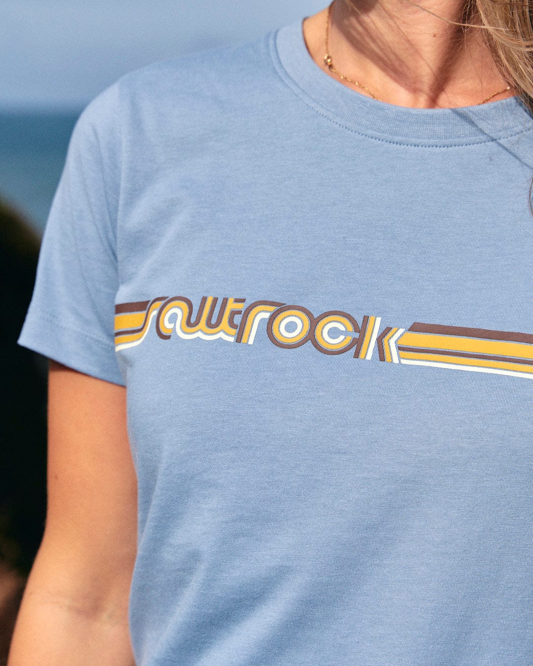 A woman wearing a Saltrock Retro Ribbon - Womens Short Sleeve T-Shirt - Light Blue.