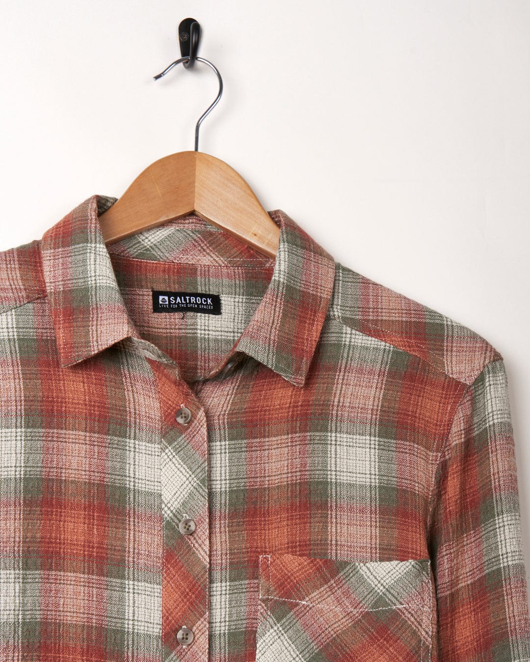 Longline Rosalin shirt by Saltrock on a wooden hanger against a white background.