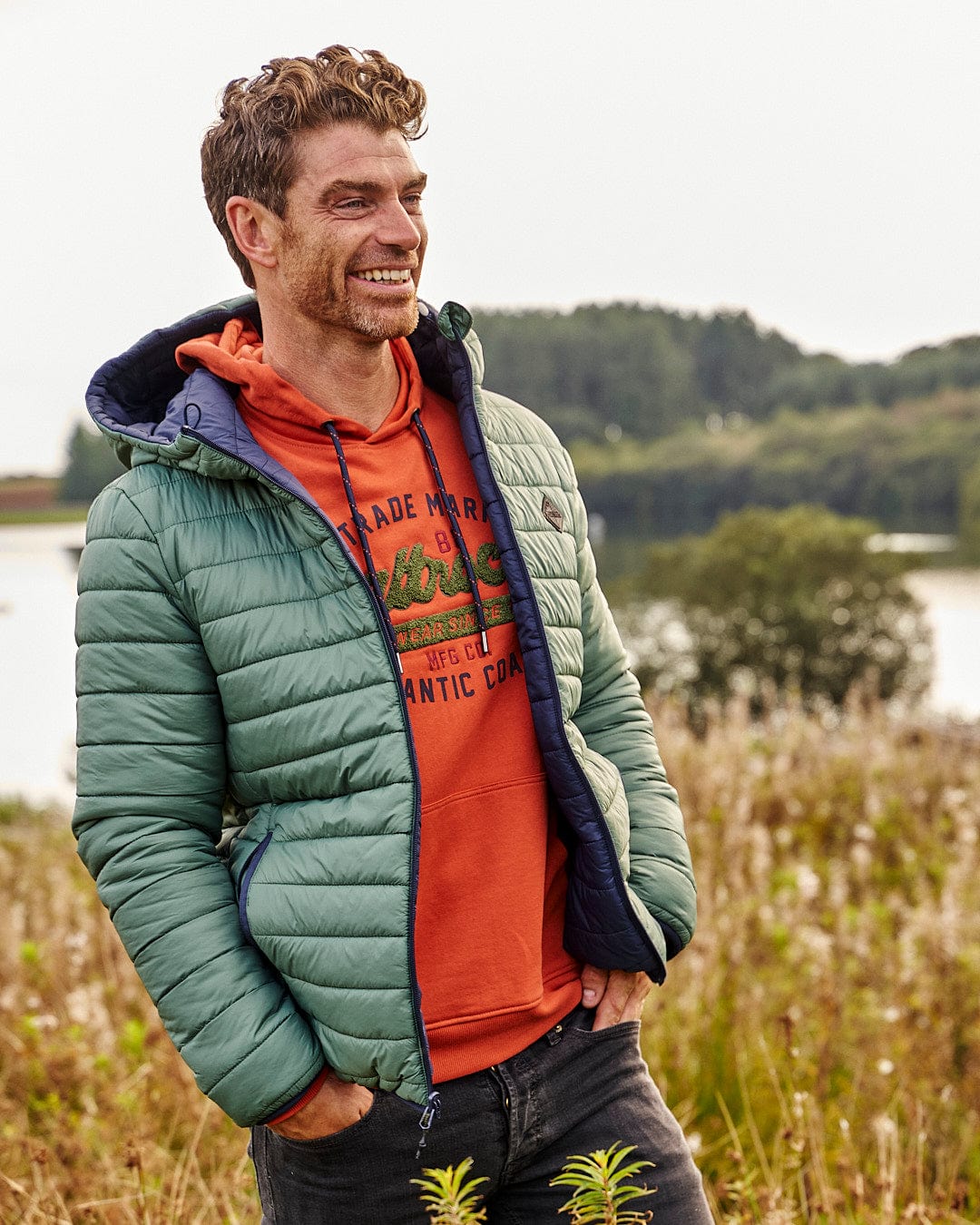 A man in a Saltrock Rusik 2 - Reversible Padded Jacket with zip pockets standing in a field.