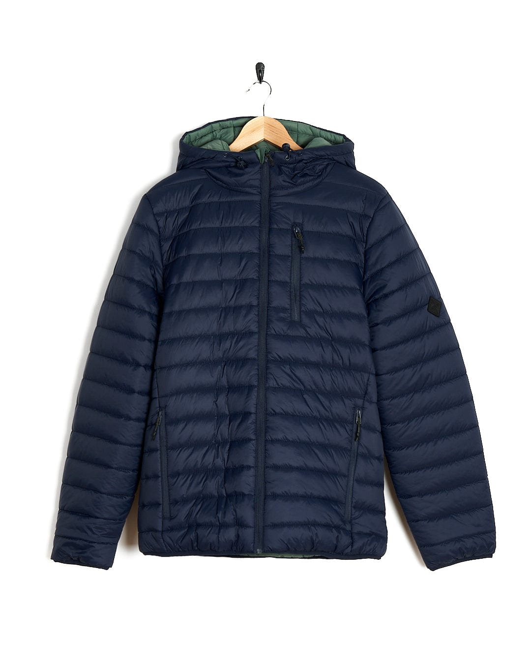 A Rusik 2 - Reversible Padded Jacket by Saltrock with zip pockets hanging on a hanger.