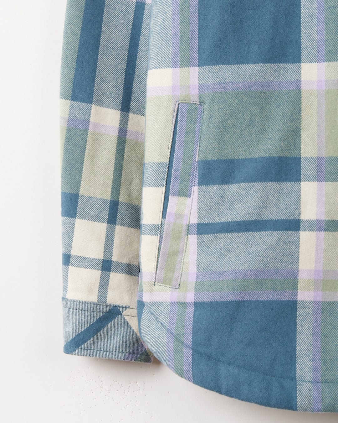 A Stella Women's Borg Lined Long Sleeve Shirt in Blue check print and green plaid hanging on a wall.