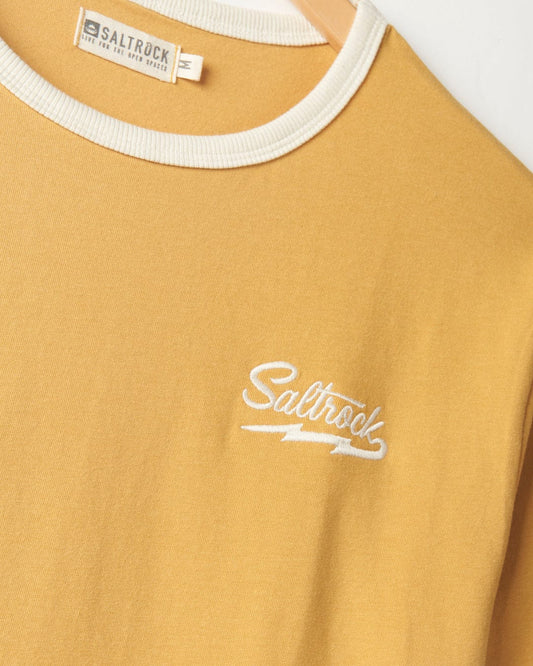 Close-up of a Strike Ringer - Mens Short Sleeve T-Shirt in mustard yellow with a white embroidered logo reading "Saltrock" on the chest, and a visible crew neckline.