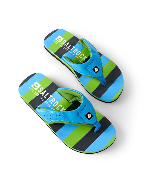The "Striped - Mens Flip Flops - Blue" by Saltrock feature blue, green, and black colors with distinct branding on the footbed. An ergonomic upper and grippy outsole enhance comfort, all presented elegantly on a white background.