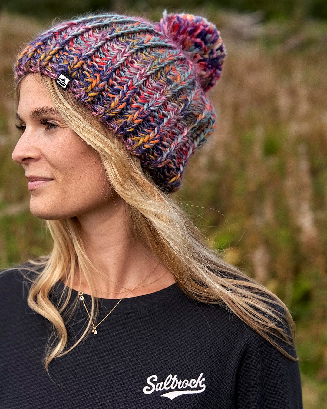 A woman wearing a Saltrock Surprise - Beanie - Multi in a field.