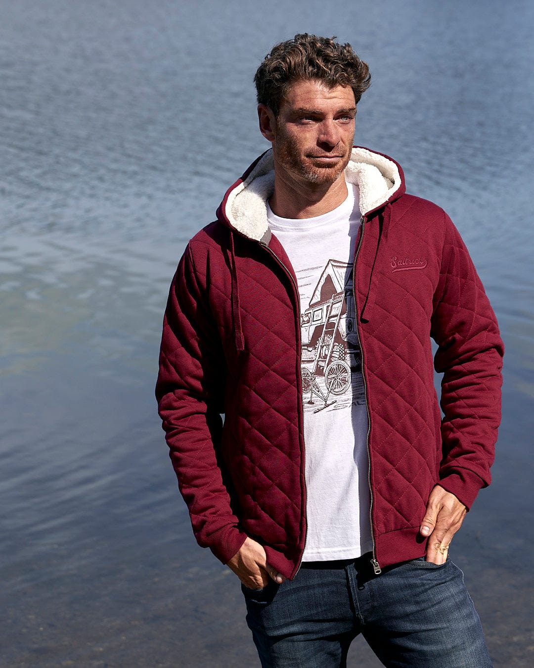 A man wearing a Saltrock Tarka - Mens Quilted Borg Lined Hoody - Red, a burgundy hooded jacket featuring quilted fabric.